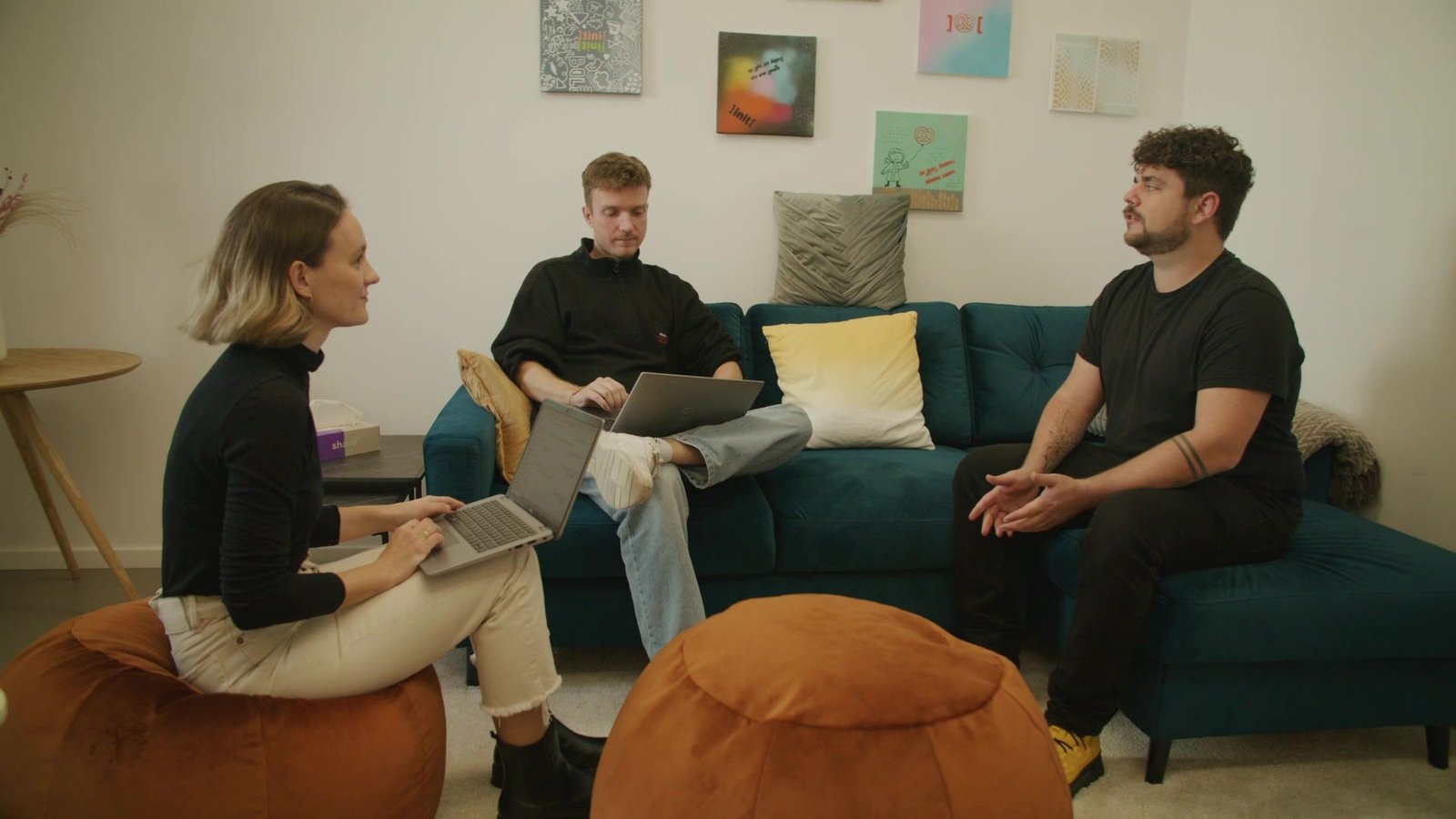 Drei Kolleginnen und Kollegen arbeiten gemeinsam mit Laptops in der INIT-Lounge