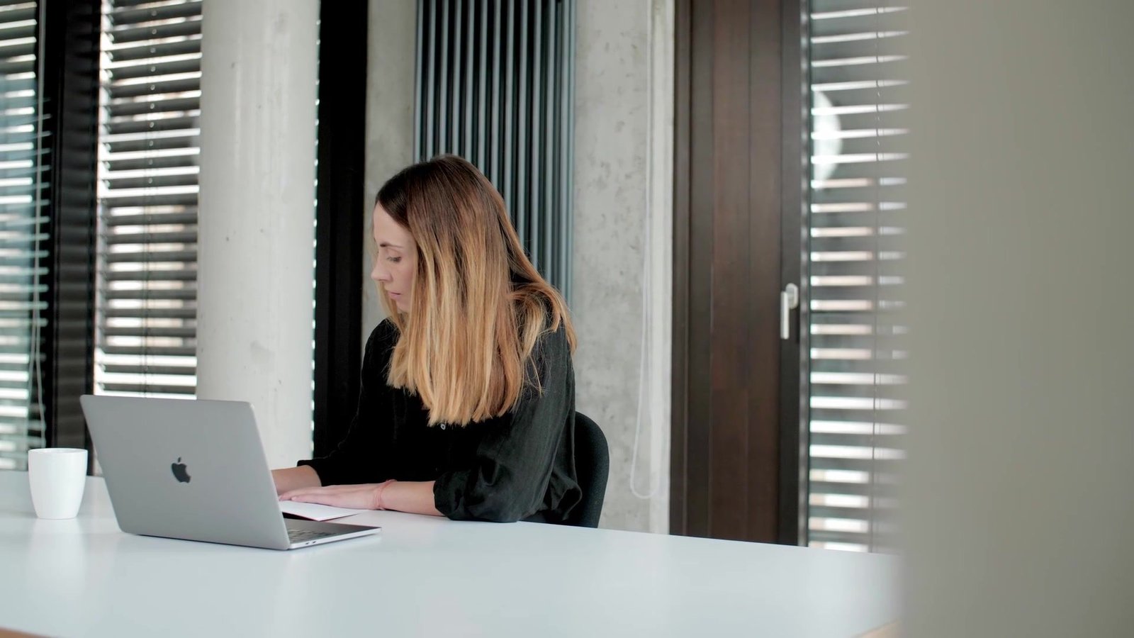 UX-Designerin arbeitet am Laptop im modernen Büro der init AG