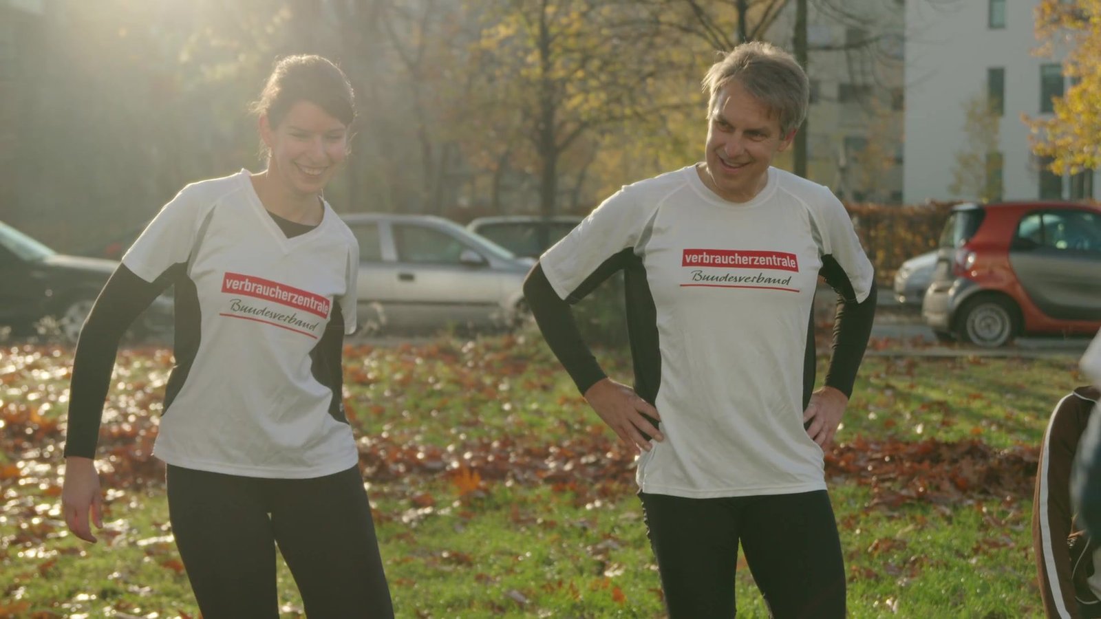 Zwei Mitarbeitende in Verbraucherzentrale-Shirts beim Sport im Herbstlicht